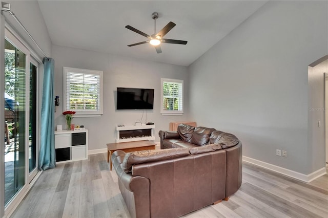 16367 Ashington Park Dr, Tampa, FL 33647 - living area featuring arched walkways, a ceiling fan, light wood finished floors, vaulted ceiling, and baseboards