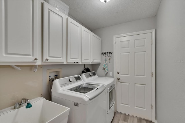 16367 Ashington Park Dr, Tampa, FL 33647 - laundry area featuring cabinet space, washer and clothes dryer, light wood finished floors, and a textured ceiling