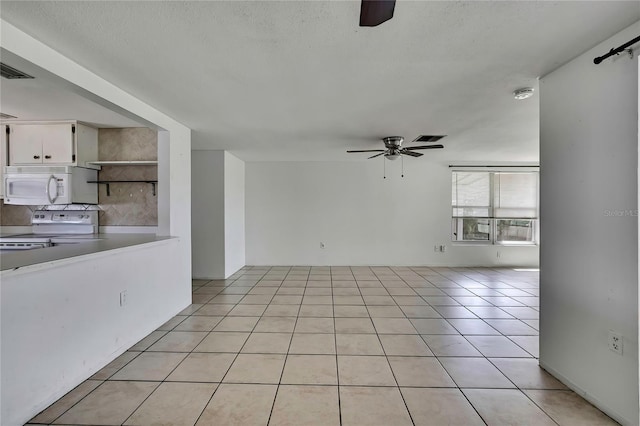 7810 Pineapple Ln, Port Richey, FL 34668 - spare room featuring a ceiling fan, light tile patterned floors, and a textured ceiling