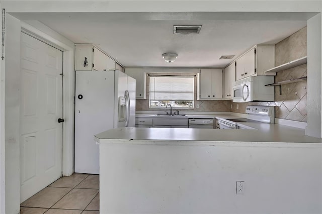 7810 Pineapple Ln, Port Richey, FL 34668 - kitchen featuring white appliances, open shelves, a sink, a peninsula, and light countertops