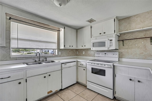 7810 Pineapple Ln, Port Richey, FL 34668 - kitchen with white appliances, a sink, light countertops, a textured ceiling, and decorative backsplash