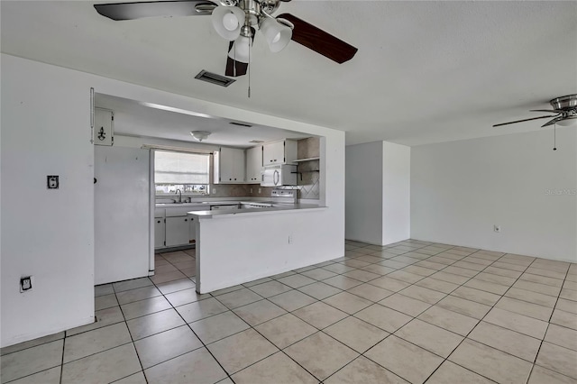 7810 Pineapple Ln, Port Richey, FL 34668 - kitchen featuring white appliances, ceiling fan, open shelves, open floor plan, and a peninsula