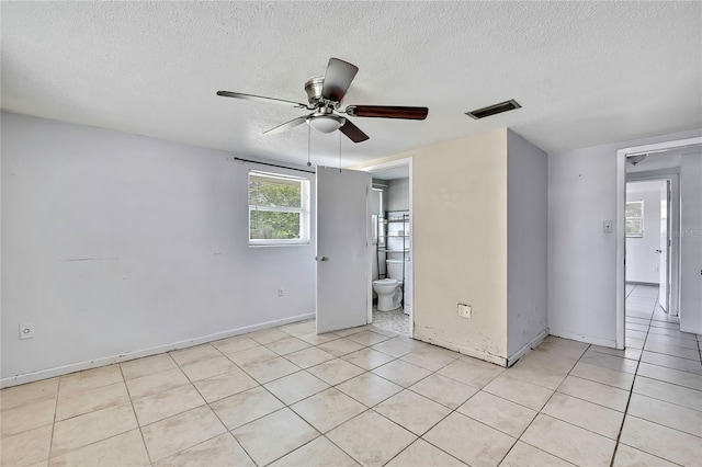 7810 Pineapple Ln, Port Richey, FL 34668 - empty room featuring a textured ceiling, light tile patterned floors, a ceiling fan, and baseboards