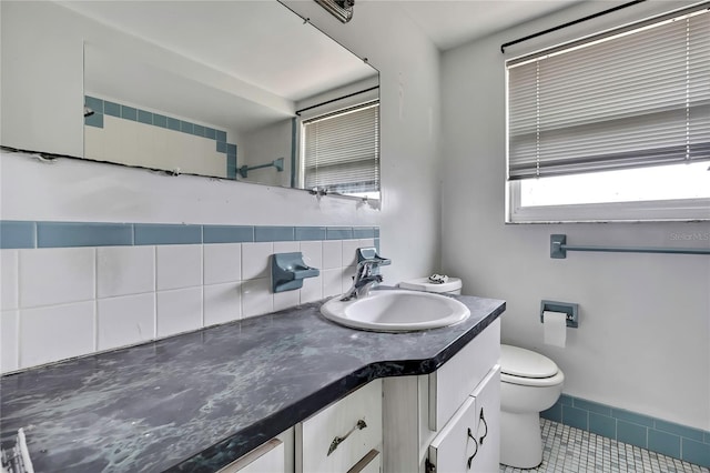 7810 Pineapple Ln, Port Richey, FL 34668 - bathroom with toilet, vanity, tile patterned floors, and decorative backsplash