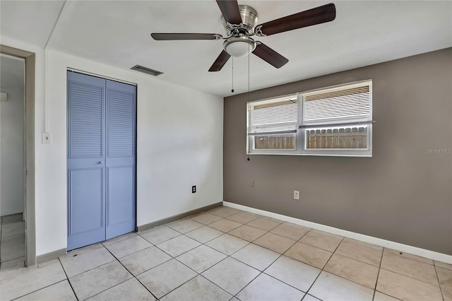 7810 Pineapple Ln, Port Richey, FL 34668 - unfurnished bedroom with a closet, baseboards, a ceiling fan, and light tile patterned floors