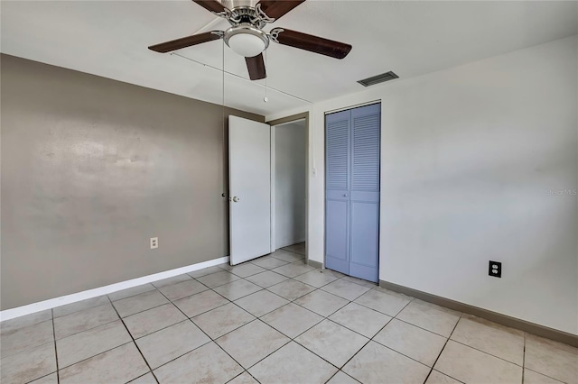 7810 Pineapple Ln, Port Richey, FL 34668 - unfurnished bedroom featuring baseboards, a closet, light tile patterned floors, and a ceiling fan