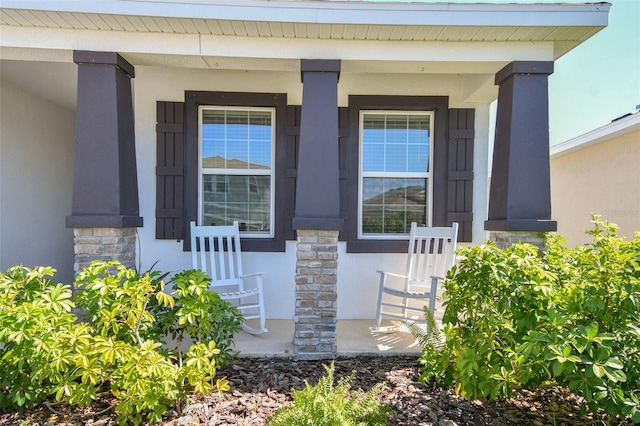 12517 Nantahala Run, Parrish, FL 34219 - view of exterior entry with stone siding, stucco siding, and covered porch