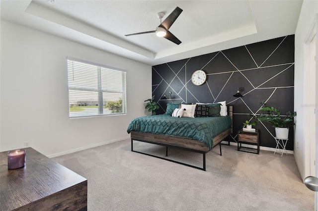 12517 Nantahala Run, Parrish, FL 34219 - bedroom featuring a tray ceiling, baseboards, carpet flooring, an accent wall, and a ceiling fan