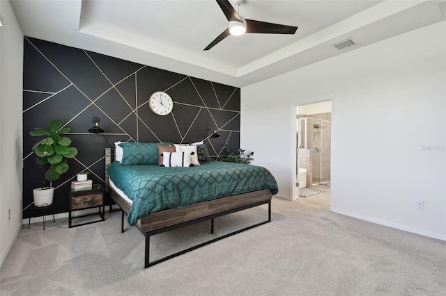 12517 Nantahala Run, Parrish, FL 34219 - carpeted bedroom featuring an accent wall, baseboards, a tray ceiling, and connected bathroom