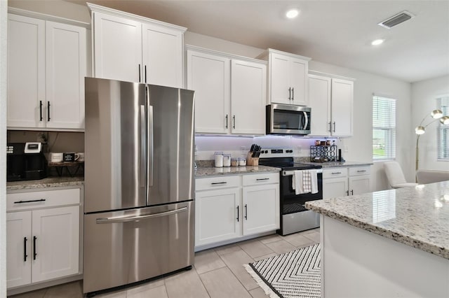 12517 Nantahala Run, Parrish, FL 34219 - kitchen featuring appliances with stainless steel finishes, white cabinets, light stone counters, recessed lighting, and light tile patterned floors