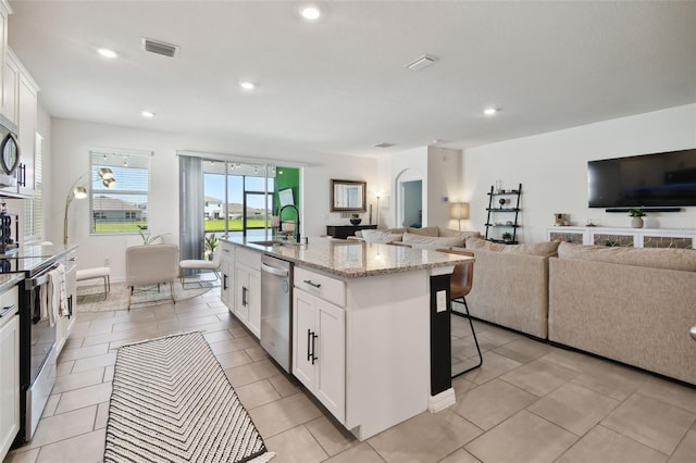 12517 Nantahala Run, Parrish, FL 34219 - kitchen featuring appliances with stainless steel finishes, open floor plan, a sink, a breakfast bar area, and recessed lighting
