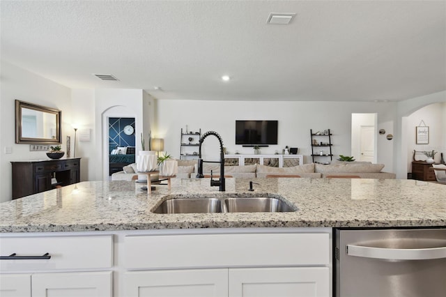 12517 Nantahala Run, Parrish, FL 34219 - kitchen with dishwasher, open floor plan, a sink, white cabinetry, and light stone countertops