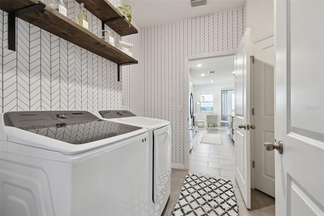 12517 Nantahala Run, Parrish, FL 34219 - laundry area featuring wallpapered walls, washer and dryer, and light tile patterned floors