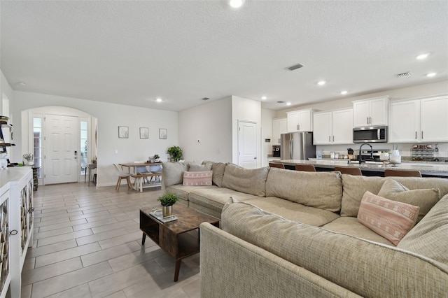 12517 Nantahala Run, Parrish, FL 34219 - living room with recessed lighting, arched walkways, and a textured ceiling