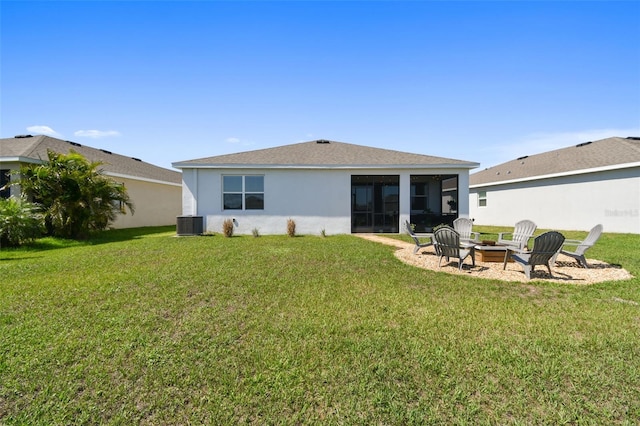 12517 Nantahala Run, Parrish, FL 34219 - rear view of house with an outdoor fire pit, stucco siding, a lawn, a sunroom, and central AC unit