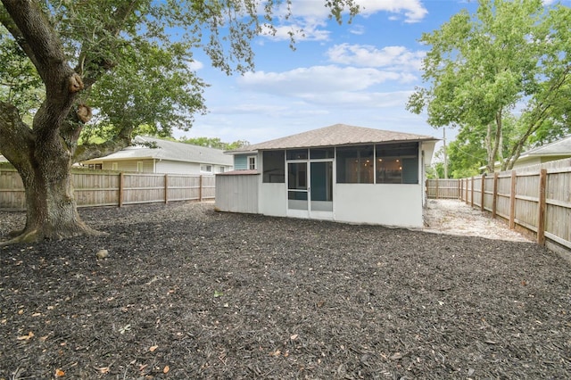 105 1st Ave SE, Lutz, FL 33549 - back of property with a sunroom, a fenced backyard, and a shingled roof