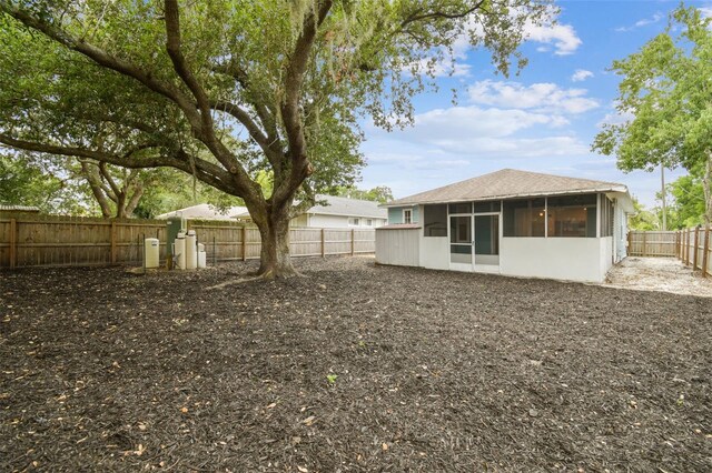 105 1st Ave SE, Lutz, FL 33549 - rear view of property with a sunroom, a fenced backyard, and a shingled roof