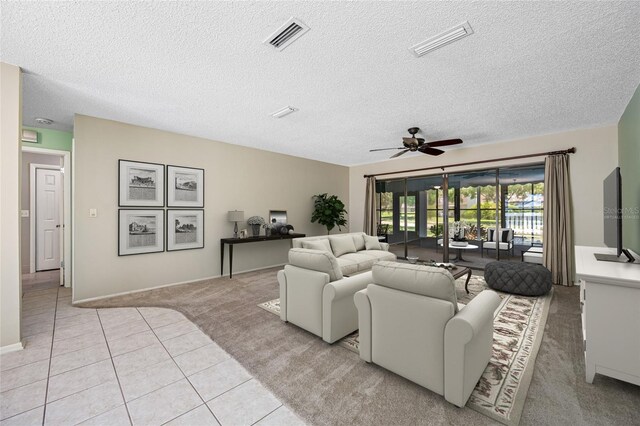 70 Cypress Pl, Oldsmar, FL 34677 - living room with light colored carpet, ceiling fan, light tile patterned floors, a textured ceiling, and baseboards