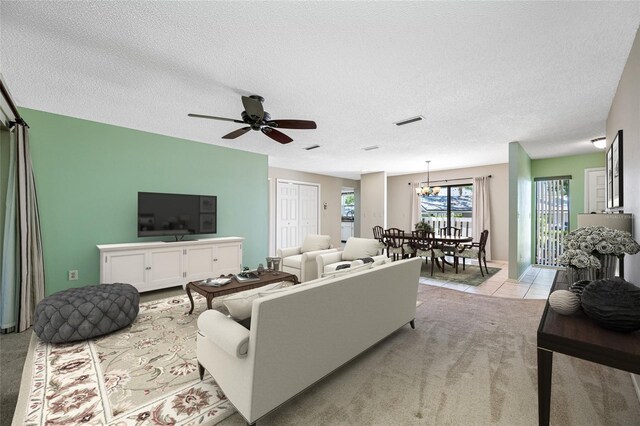 70 Cypress Pl, Oldsmar, FL 34677 - living area featuring light carpet, a ceiling fan, a textured ceiling, a chandelier, and light tile patterned floors