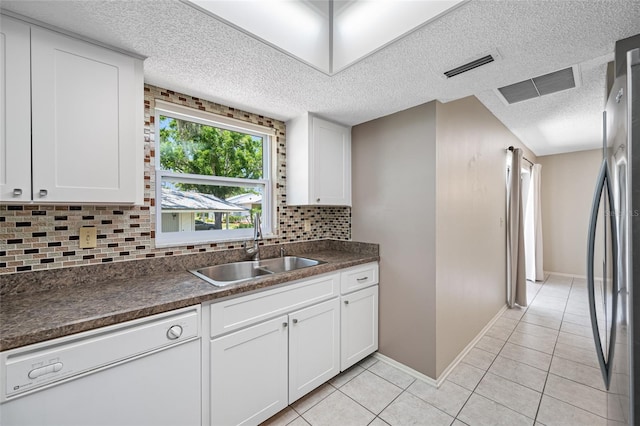 70 Cypress Pl, Oldsmar, FL 34677 - kitchen featuring white dishwasher, a sink, freestanding refrigerator, a textured ceiling, and decorative backsplash