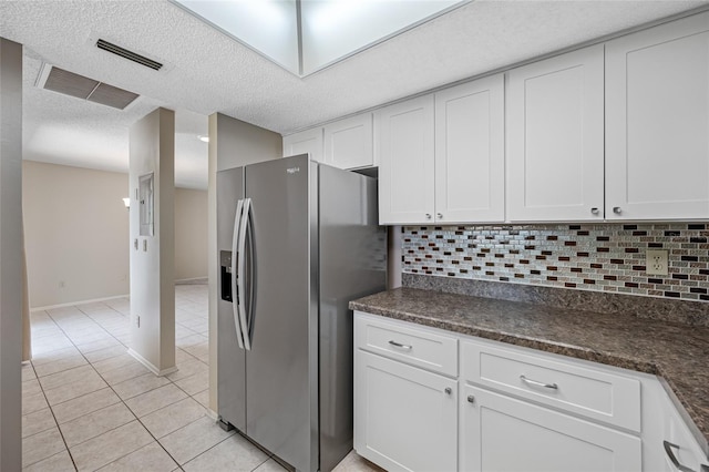 70 Cypress Pl, Oldsmar, FL 34677 - kitchen featuring stainless steel fridge with ice dispenser, light tile patterned floors, white cabinetry, tasteful backsplash, and a textured ceiling