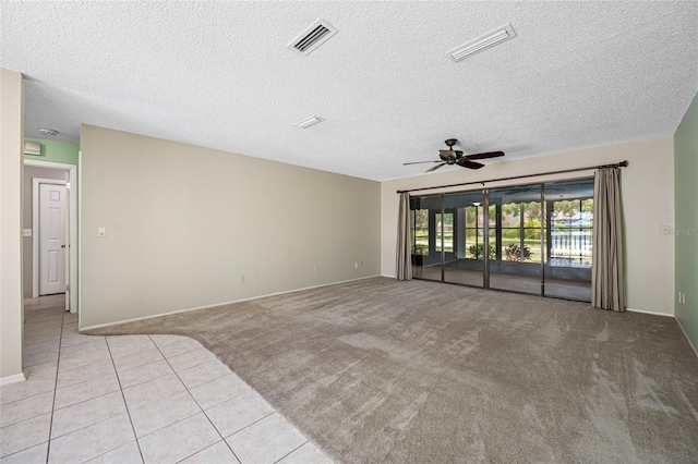 70 Cypress Pl, Oldsmar, FL 34677 - unfurnished room featuring ceiling fan, light colored carpet, light tile patterned flooring, baseboards, and a textured ceiling