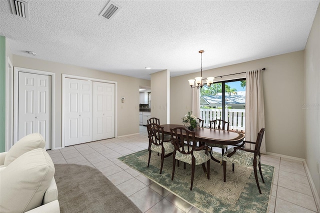 70 Cypress Pl, Oldsmar, FL 34677 - dining area with a chandelier, light tile patterned flooring, baseboards, and a textured ceiling