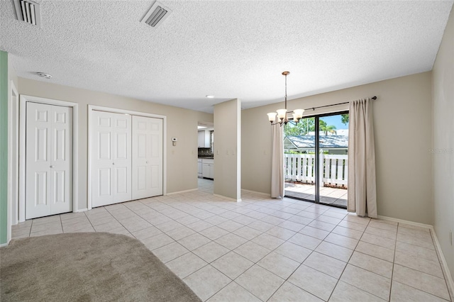 70 Cypress Pl, Oldsmar, FL 34677 - unfurnished dining area with a chandelier, light tile patterned floors, baseboards, and a textured ceiling