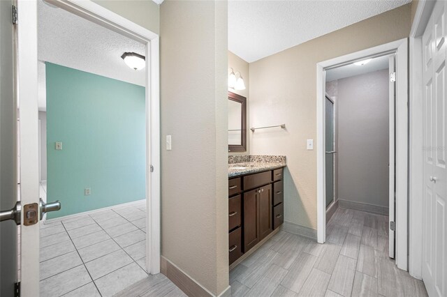 70 Cypress Pl, Oldsmar, FL 34677 - bathroom featuring vanity, a stall shower, a textured ceiling, and baseboards