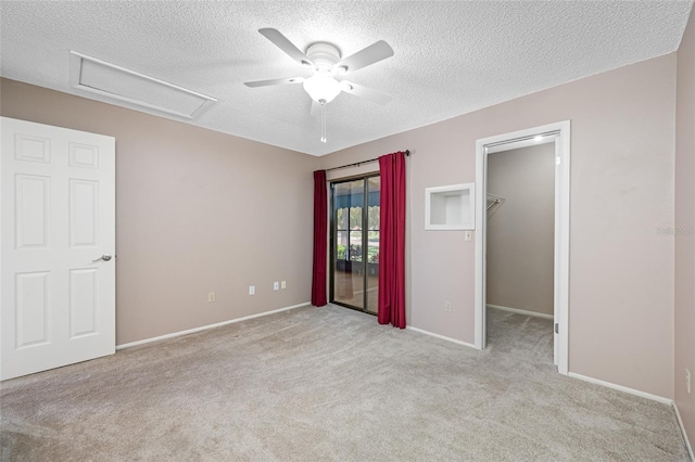 70 Cypress Pl, Oldsmar, FL 34677 - unfurnished bedroom featuring attic access, carpet, a textured ceiling, a walk in closet, and baseboards