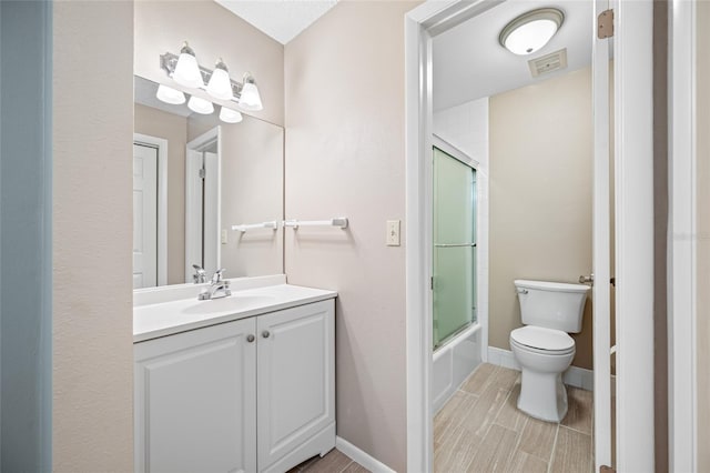 70 Cypress Pl, Oldsmar, FL 34677 - bathroom with toilet, vanity, combined bath / shower with glass door, and baseboards