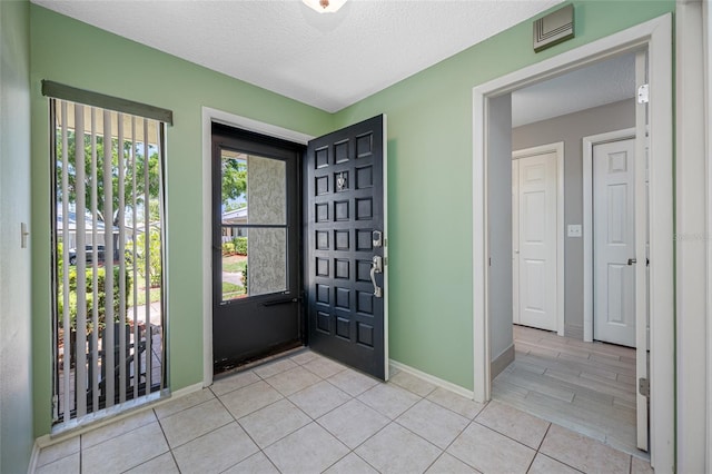 70 Cypress Pl, Oldsmar, FL 34677 - foyer entrance featuring baseboards, light tile patterned floors, and a textured ceiling