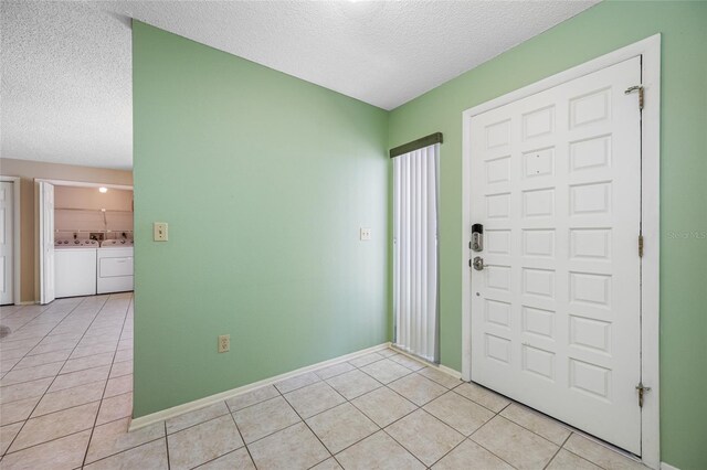 70 Cypress Pl, Oldsmar, FL 34677 - foyer with separate washer and dryer, a textured ceiling, light tile patterned flooring, and baseboards
