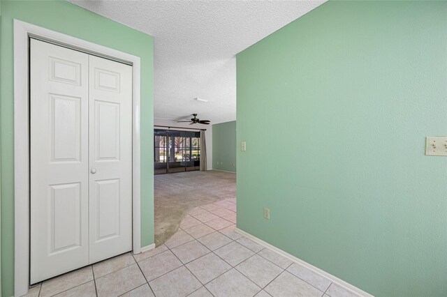 70 Cypress Pl, Oldsmar, FL 34677 - corridor featuring a textured ceiling, light tile patterned floors, light colored carpet, and baseboards