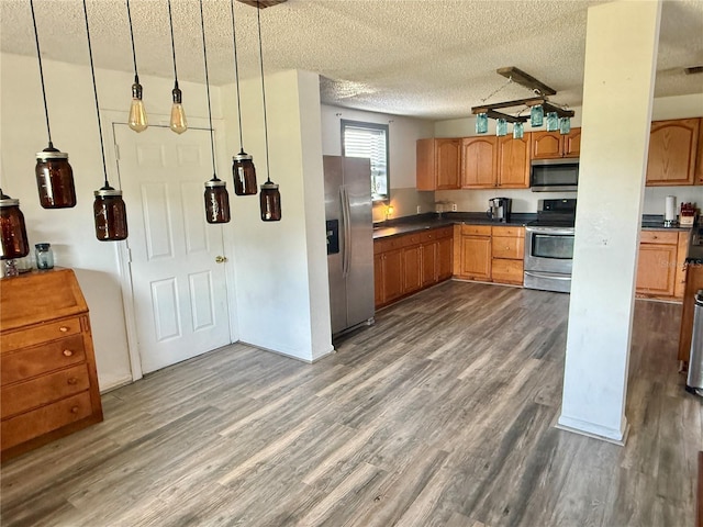439 Corbett Rd, Lithia, FL 33547 - kitchen featuring stainless steel appliances, dark countertops, dark wood finished floors, a textured ceiling, and brown cabinets