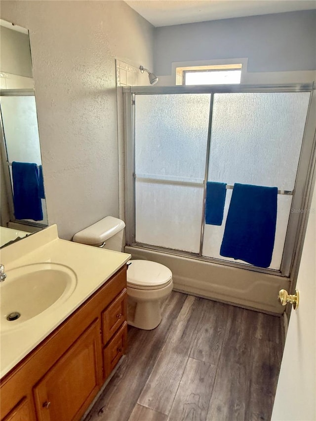 439 Corbett Rd, Lithia, FL 33547 - full bath featuring vanity, toilet, wood finished floors, combined bath / shower with glass door, and a textured wall