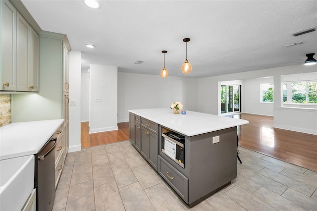 1766 Hitching Post Ln, Dunedin, FL 34698 - kitchen featuring gray cabinets, open floor plan, light countertops, a center island, and recessed lighting