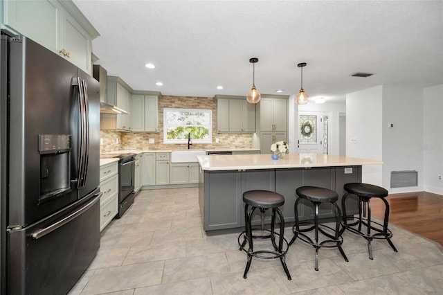 1766 Hitching Post Ln, Dunedin, FL 34698 - kitchen with stainless steel refrigerator with ice dispenser, black range with electric stovetop, wall chimney range hood, decorative backsplash, and a kitchen bar