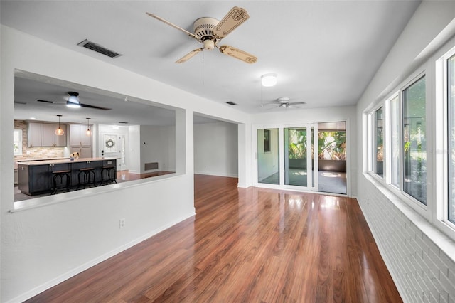 1766 Hitching Post Ln, Dunedin, FL 34698 - unfurnished living room with a ceiling fan, wood finished floors, and baseboards