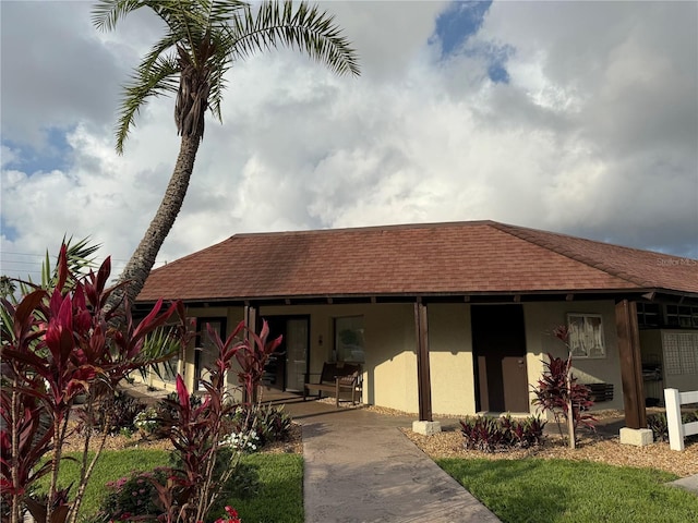 1100 E Bay Dr Unit 96, Largo, FL 33770 - view of front facade with covered porch, a shingled roof, and stucco siding