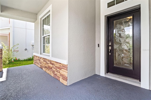 7725 Tangle Rush Dr, Gibsonton, FL 33534 - view of exterior entry with stucco siding and a porch