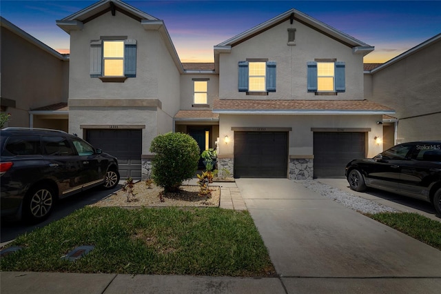 12353 Bayou Flats Ln, Tampa, FL 33635 - view of front of home with an attached garage, stucco siding, driveway, and stone siding