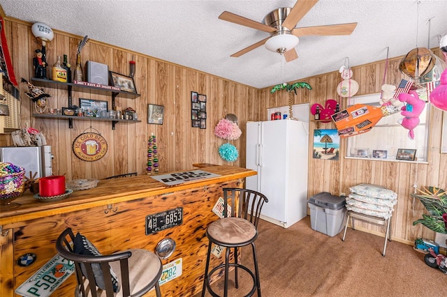 10400 112th Way, Largo, FL 33778 - kitchen with wooden walls, freestanding refrigerator, ceiling fan, carpet, and a textured ceiling