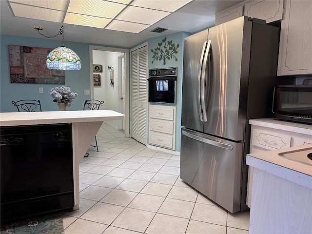 10400 112th Way, Largo, FL 33778 - kitchen with black appliances, light tile patterned floors, light countertops, and hanging light fixtures