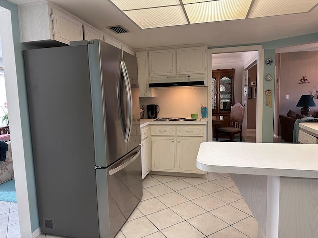 10400 112th Way, Largo, FL 33778 - kitchen featuring freestanding refrigerator, under cabinet range hood, light tile patterned flooring, and light countertops