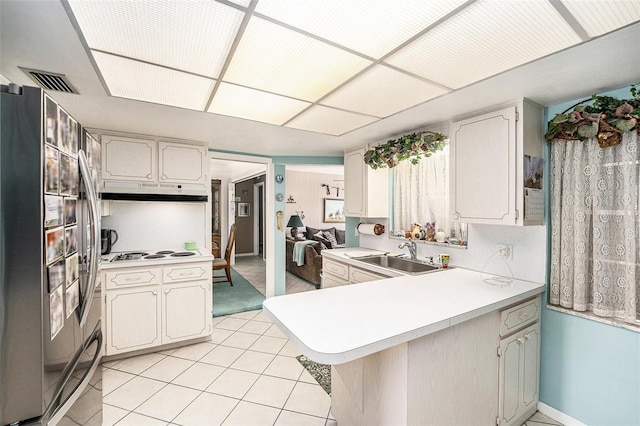 10400 112th Way, Largo, FL 33778 - kitchen with fridge, a sink, a peninsula, light countertops, and light tile patterned floors