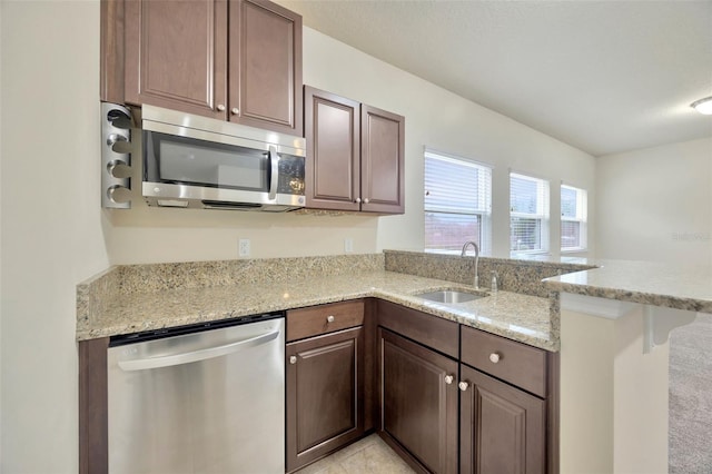 1229 Hillandale Reserve Dr, Tampa, FL 33613 - kitchen with appliances with stainless steel finishes, a peninsula, and light stone countertops