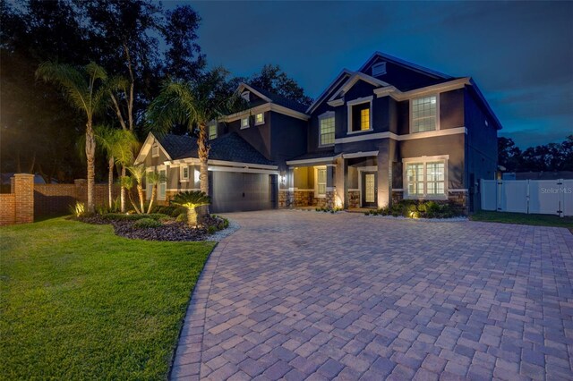 1229 Hillandale Reserve Dr, Tampa, FL 33613 - view of front facade featuring stucco siding, a gate, decorative driveway, and an attached garage