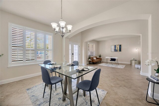 1229 Hillandale Reserve Dr, Tampa, FL 33613 - dining area featuring arched walkways, a chandelier, and light tile patterned flooring