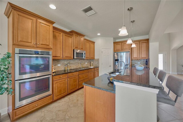 1229 Hillandale Reserve Dr, Tampa, FL 33613 - kitchen featuring stainless steel appliances, brown cabinets, dark stone countertops, and recessed lighting